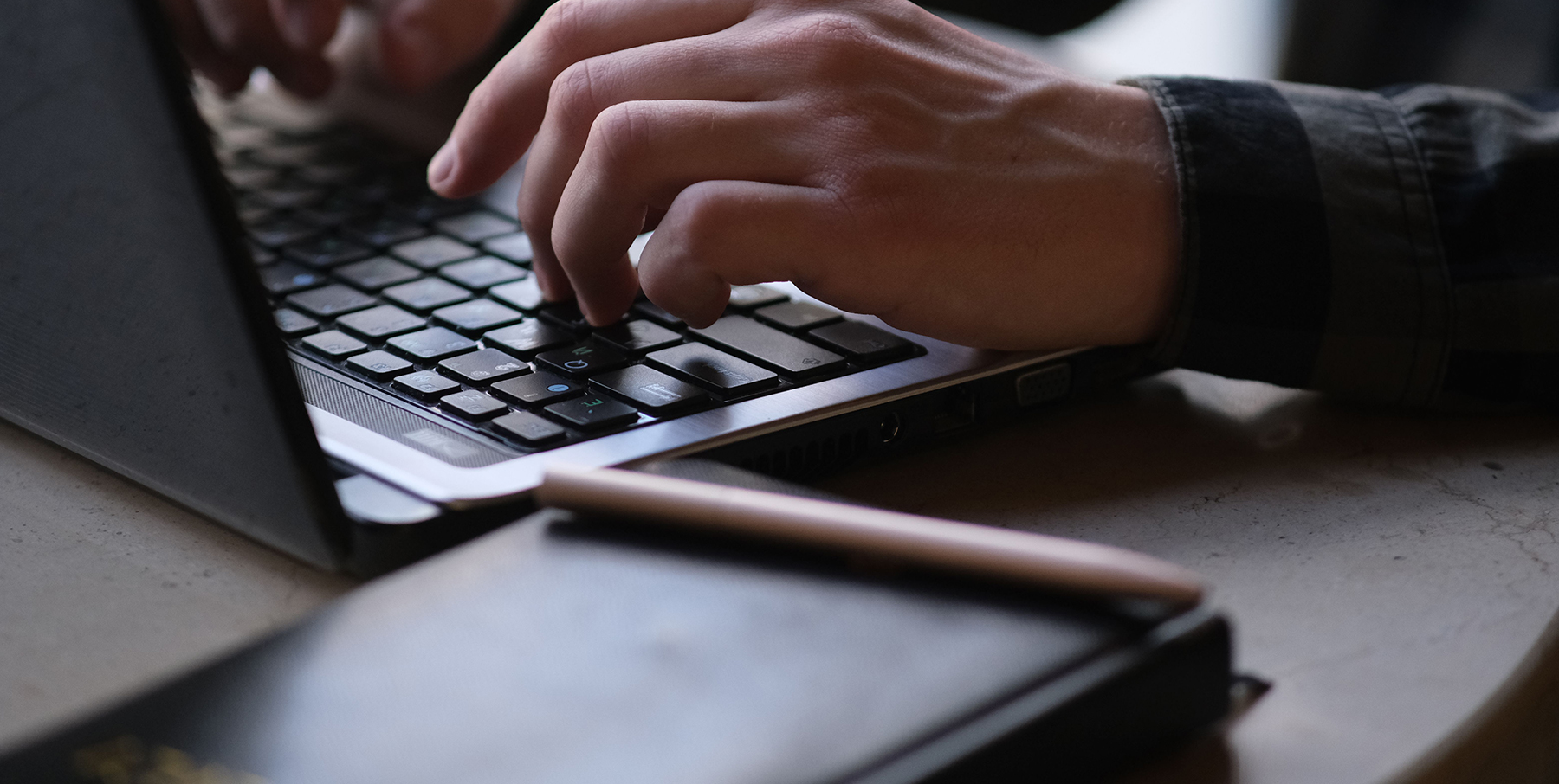 Person typing a blog on a computer keyboard.