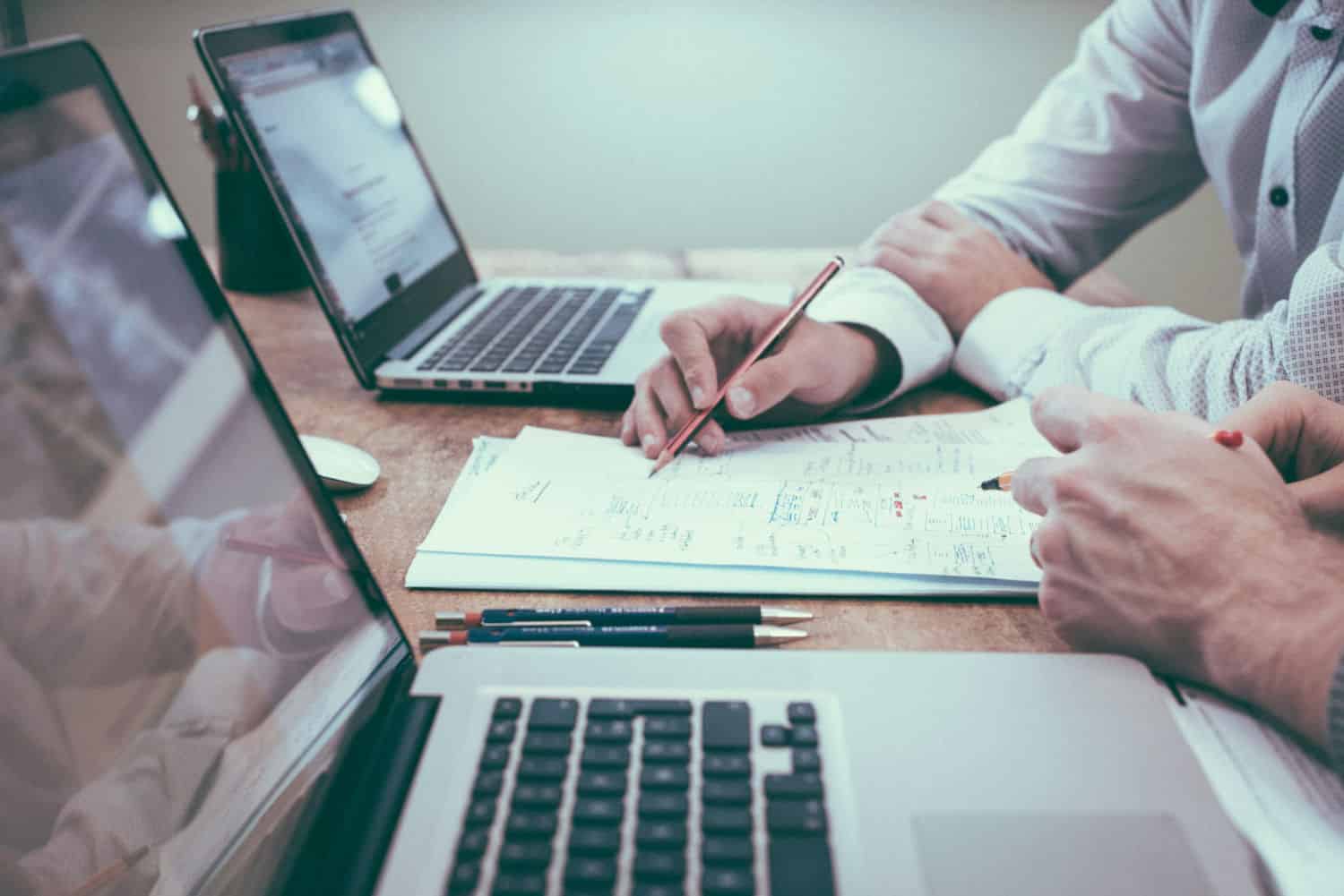 Two people reviewing website wireframes and notes together during a WordPress project planning meeting.